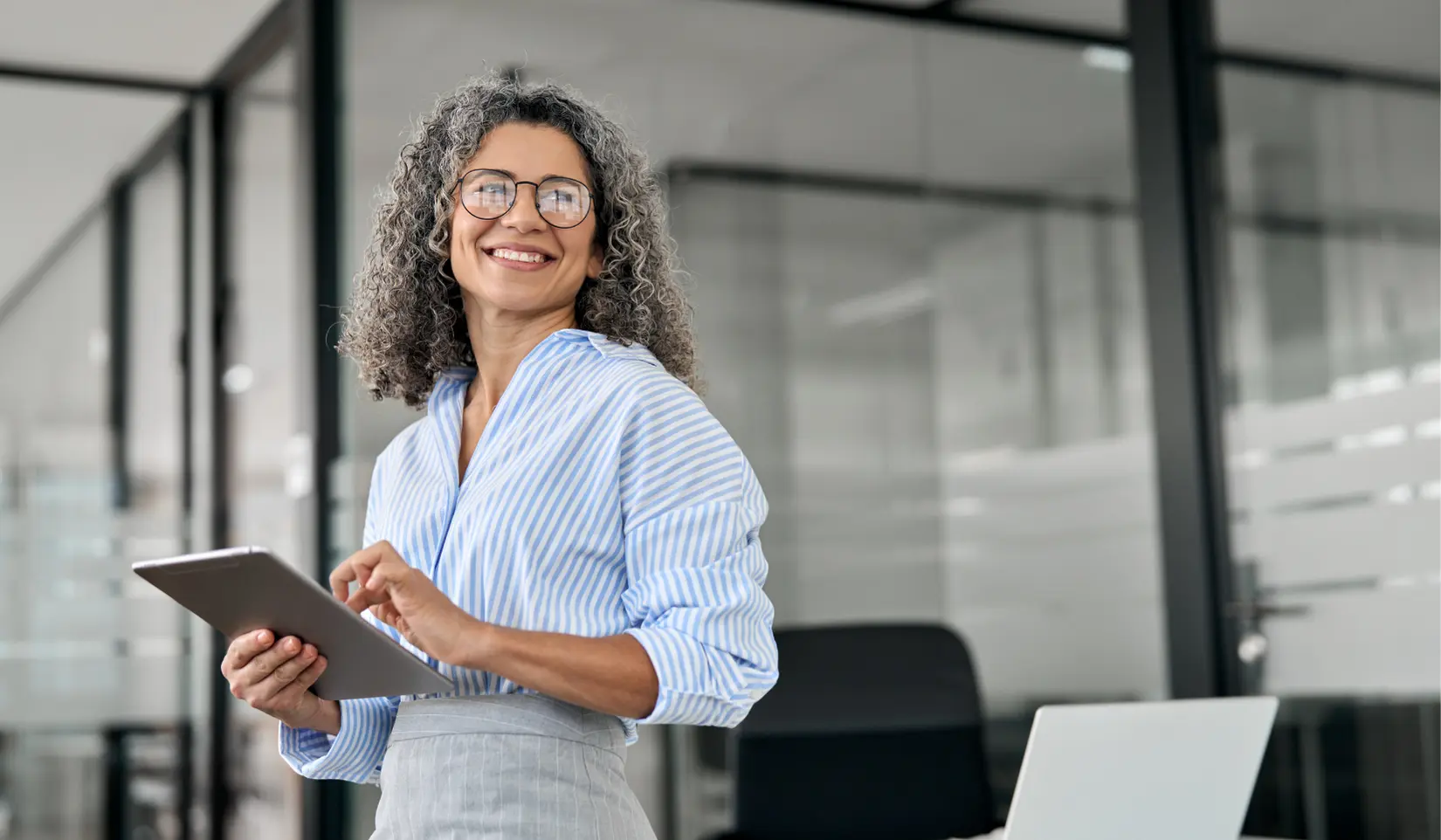 Professional woman using a tablet to manage her LinkedIn personal brand