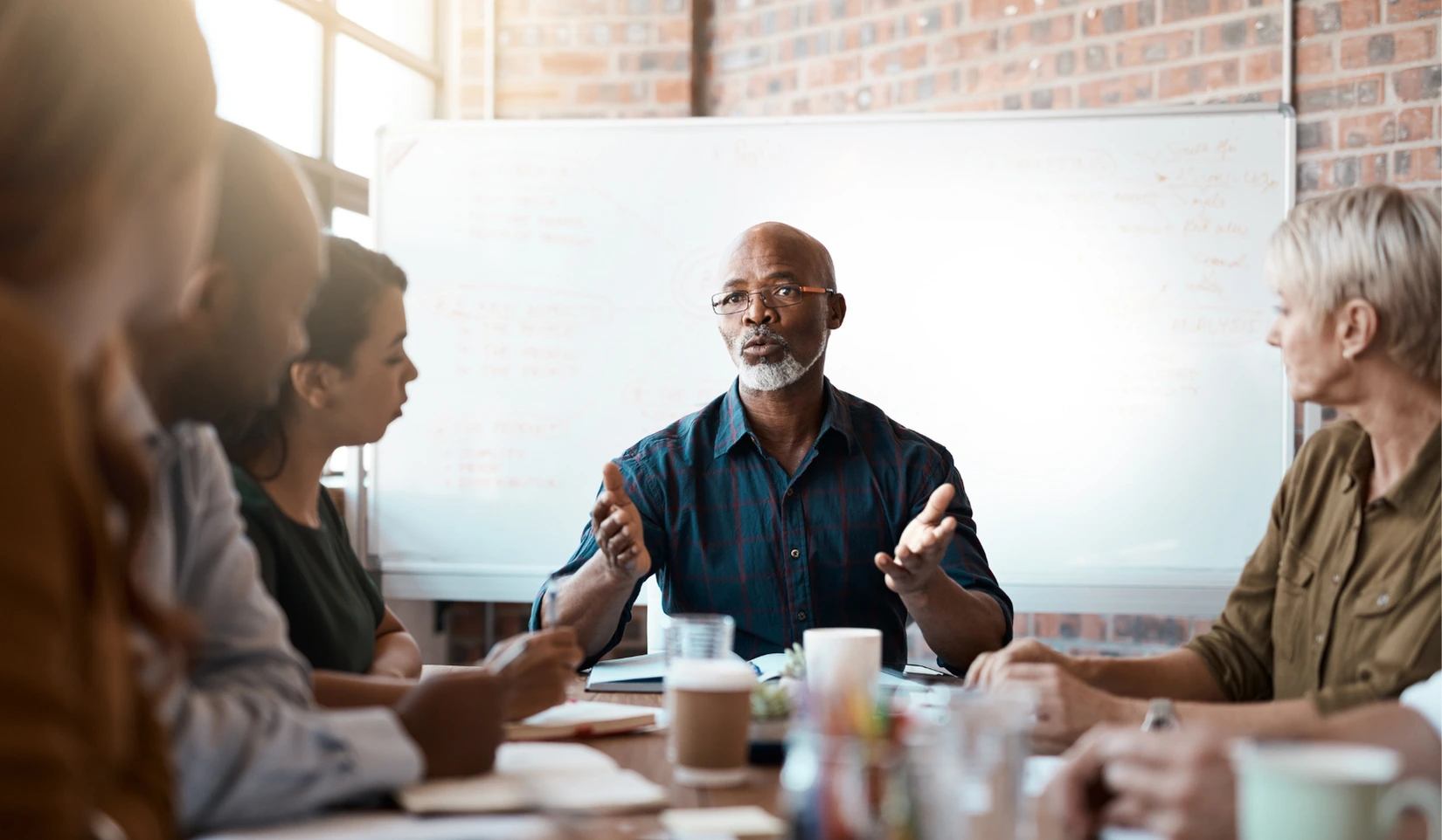 Team meeting around a table discussing the choice between a marketing agency and in-house marketing